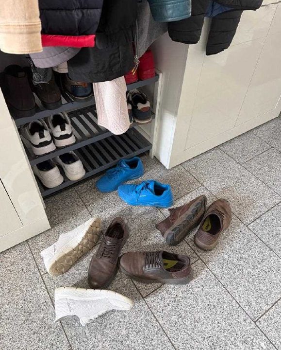 Foto aus der App: verschmutzter Hausflur mit abgestellten Schuhen